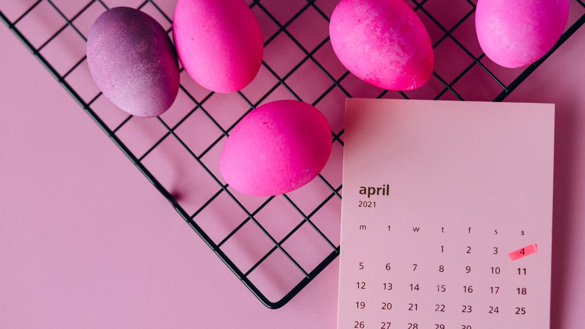 Colorful Easter eggs on a rack and an April 2021 calendar, symbolizing spring celebration.